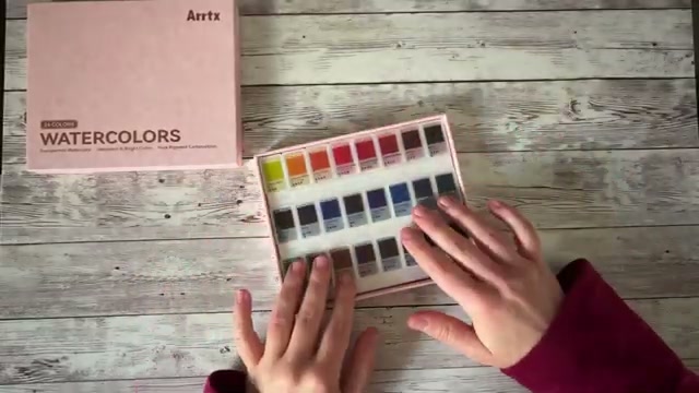 Gros plan sur le film transparent de la boîte montrant le système de repérage intelligent avec les noms des couleurs, la résistance à la lumière et l'opacité indiqués pour chaque godet