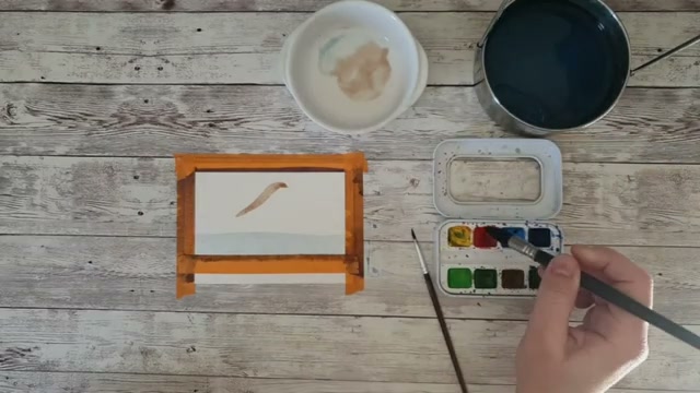 Le dos de l'oiseau est peint en terre d'ombre brûlée et l'artiste commence à appliquer le rouge vermillon pour le ventre, pinceau tenu sur la virole à la verticale