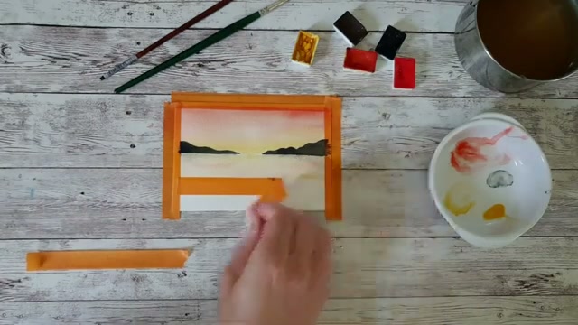 Le scotch est retiré, révélant le résultat final du paysage de coucher de soleil avec son cadre blanc net et l'inscription « 5 minutes d'automne »