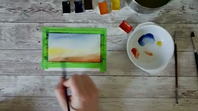 L'artiste étale le jaune Anza au centre du papier entre le bleu et le rouge, on voit les trois couleurs du dégradé en train de fusionner sur le papier mouillé avec des coups de pinceau presque horizontaux.